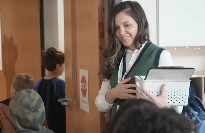 A Sterling Montessori teacher welcomes students at the classroom door